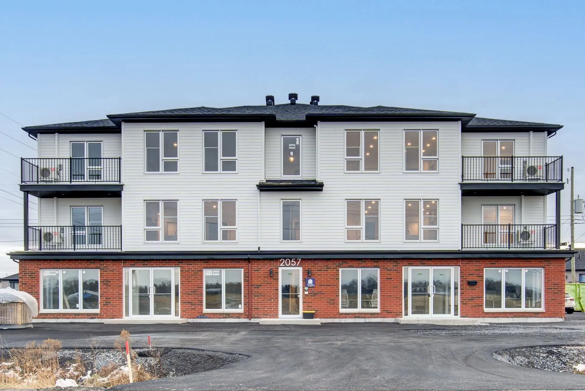 Façade du 2057, chemin Ridge : rez-de-chaussée commercial en brique et deux étages de logements